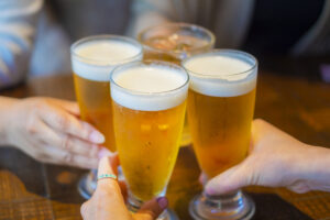 Cheers with a draft beer.