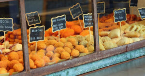 many fried foods ideal as street food displayed in the showcase with the name in Italian and the name in American USA
